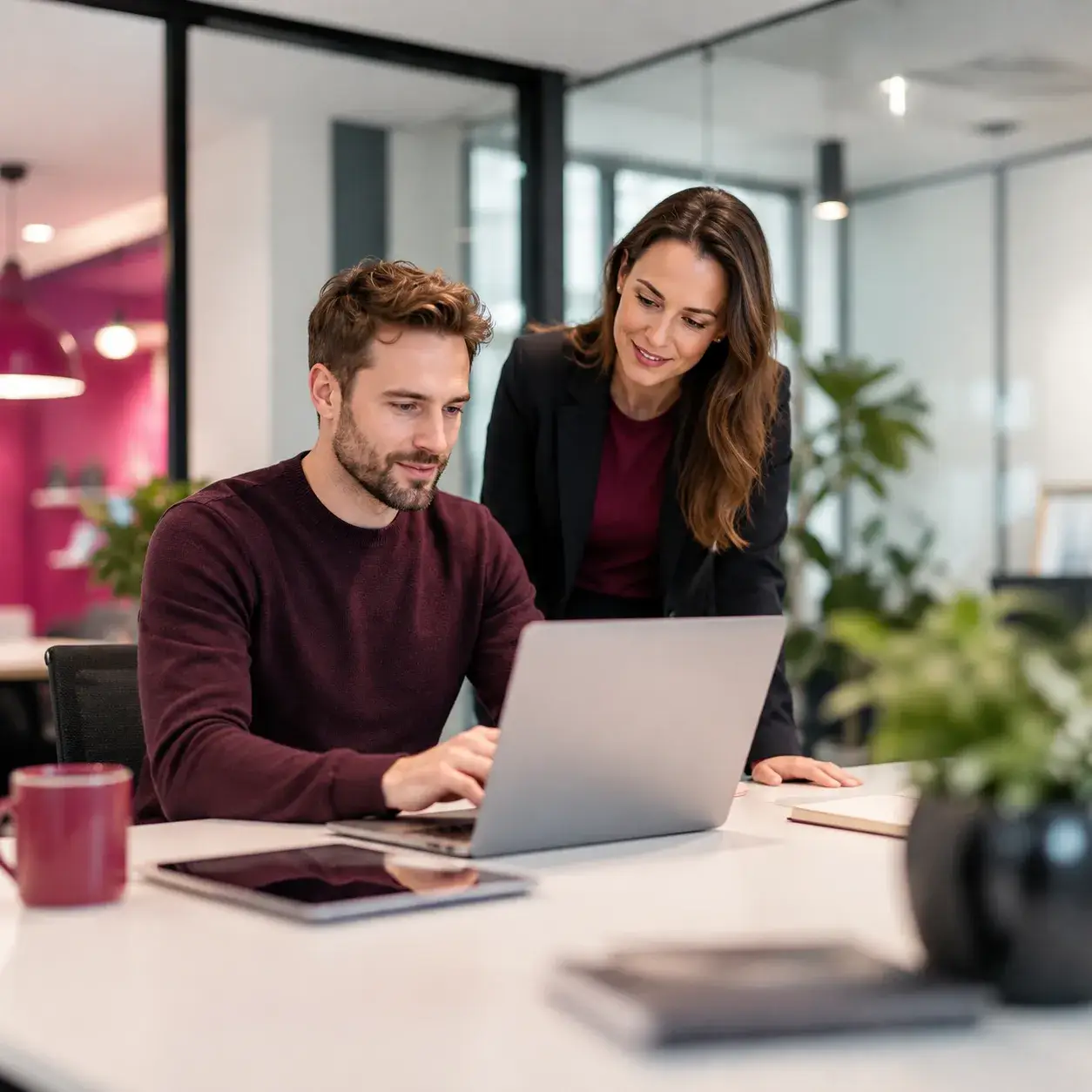 Twee professionals werken samen aan een laptop in een modern kantoor als beeld voor registratie, deelname en kennisdeling bij In IT.